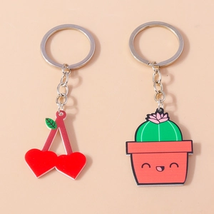 Dettaglio dei portachiavi creativi in acrilico con ciliegia a cuore e cactus sorridente