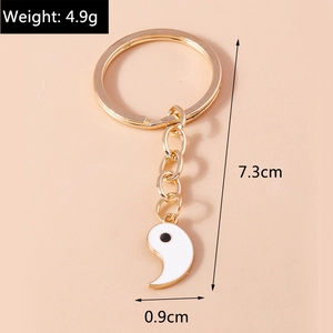 Détail d'un porte-clés Yin Yang doré en forme de cœur montrant les dimensions et le poids