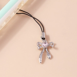 Close-up of a silver bow phone charm with a pink heart gemstone on light background