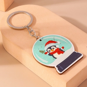 Détail d'un porte-clés pingouin de Noël avec illustration mignonne sur un pendentif rond