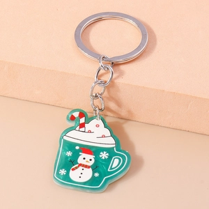 Detail shot of a green holiday cup keychain featuring a snowman and candy cane charm