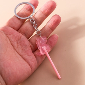 Handheld view of a pink glitter dinosaur lollipop keychain with silver metal ring
