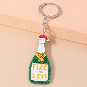Close-up of festive champagne bottle keychain with Fizz the Season text and green glitter