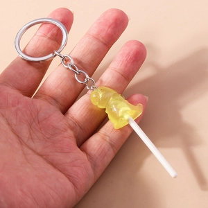 Close-up of yellow translucent resin lollipop keychain with silver metal ring and chain