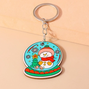 Détail d'un porte-clés bonhomme de neige de Noël sur un fond rose pastel uni