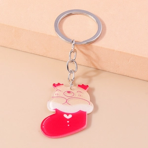 Close-up of a Christmas stocking keychain with a glittery bear charm on a warm background