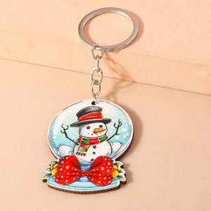 Détail d'un porte-clés boule de neige de Noël avec bonhomme de neige et nœud rouge à pois