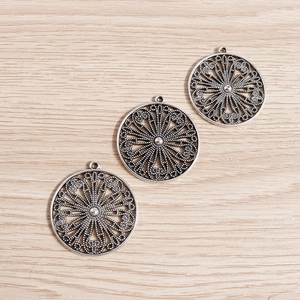 Macro detail of three antique silver hollow floral pendants for DIY jewelry making