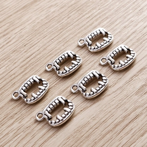 Macro detail of vintage silver vampire teeth charms for DIY jewelry and necklaces