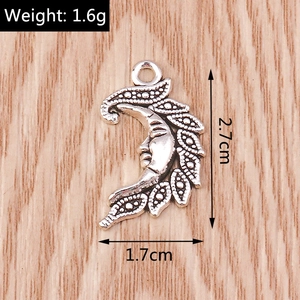 Detailed view of crescent moon face pendant with feather edges and size measurements