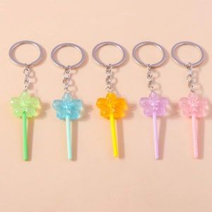 Detail of five translucent resin lollipop keychains with glitters and flower core