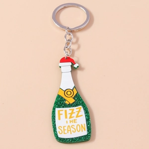 Close-up of a green glitter champagne bottle keychain with a festive Christmas hat detail