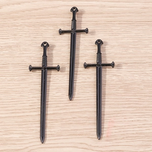 Detalle macro de tres colgantes de espada gótica negro brillante para joyas DIY