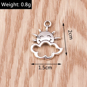 Macro shot of silver sun and cloud charms with smiling face designs and ring bail