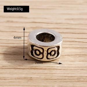 Vista macro de cuenta cilíndrica de plata retro de 7mm con círculos en relieve para joyería