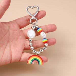 Porte-clés cœur arc-en-ciel avec perles irrégulières et perles colorées tenu en main