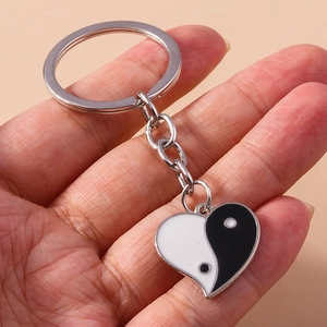 Détail d'un porte-clés pendentif cœur Tai Chi Yin Yang en métal argenté poli