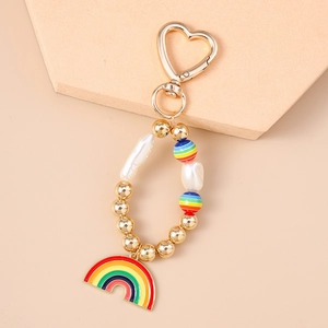 Détail du porte-clés cœur arc-en-ciel avec perles irrégulières et breloque en émail coloré