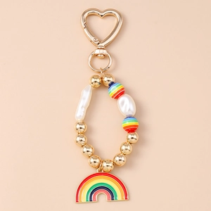 Détail du porte-clés perlé avec fermoir cœur doré et pendentif arc-en-ciel émaillé
