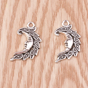 Macro view of vintage silver crescent moon face pendants for DIY jewelry design