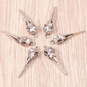 Detailed view of six antique silver bird skull pendants for gothic jewelry making