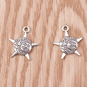 Detailed view of two vintage silver sun face pendants with relief texture for DIY jewelry