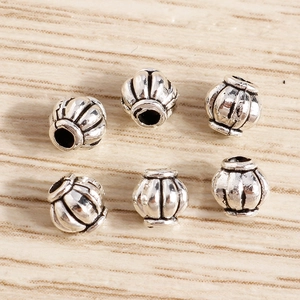 Vista detallada de cuentas plateadas retro con forma de calabaza y textura para joyería DIY