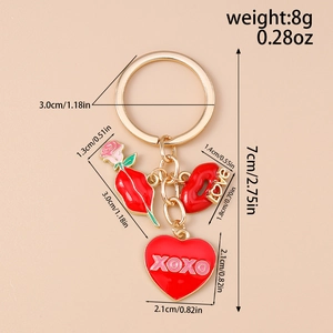 Détail de breloques en émail rouge avec rose, lèvres et cœur XOXO sur porte-clés doré