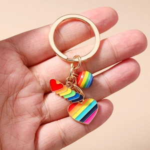 Rainbow heart keychain with gold alloy ring and colorful enamel charms held in hand