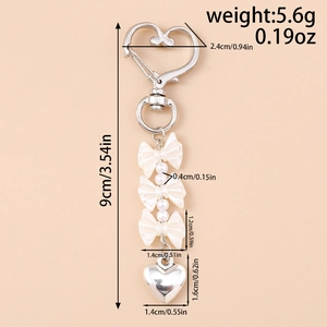 Dettaglio portachiavi con fiocco di perle, chiusura a cuore e lunghezza totale di 9cm