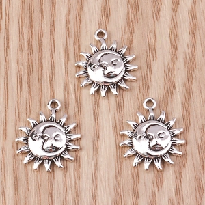 Detailed close-up of antique silver sun and moon charms for DIY jewelry making