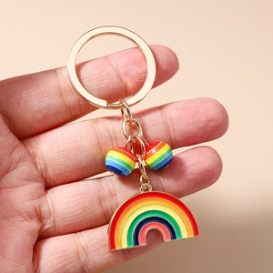 Chic rainbow enamel keychain with gold ring and colorful striped beads on handheld display