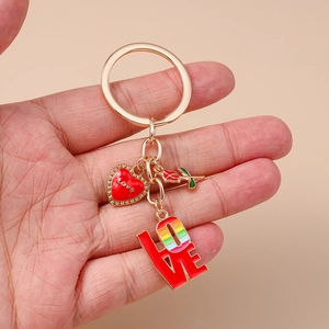 Vue détaillée d'un porte-clés doré avec cœur et rose et pendentifs LOVE colorés en émail