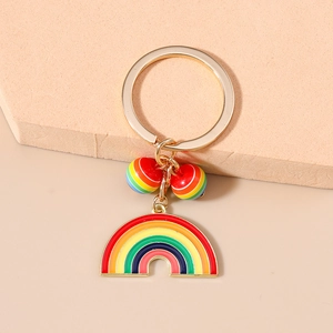 Close-up of a golden alloy rainbow keychain with colorful enamel charm and beaded details