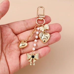 Golden heart keychain with white pearls and rhinestone bow charm accessory