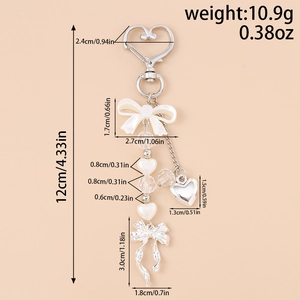 Detail view of heart keychain with pearls and bow pendant showing size measurements