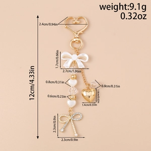 Detail of heart keychain with bow and pearl charms showing dimensions and weight