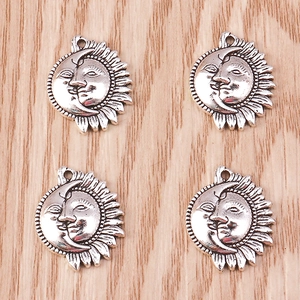 Set of four antique silver sun and moon pendants with detailed celestial relief patterns