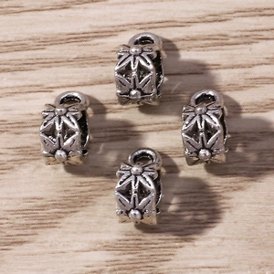 Set of retro floral silver alloy beads for DIY jewelry making on wooden background