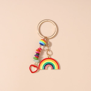 Detail of a rainbow keychain featuring colorful beads, stones, and a red heart pendant