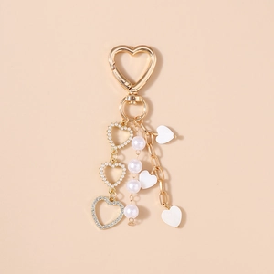 Close-up of golden heart keychain with pearl chains and sparkling rhinestone accents