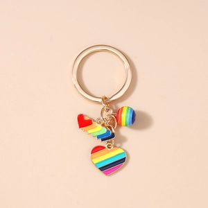 Detail of gold metal keychain with rainbow enamel hearts and striped round bead charm