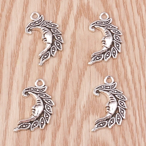 Macro shot of four vintage silver crescent moon charms for DIY necklace making