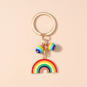 Detail of a rainbow keychain featuring a golden ring, enamel pendant, and striped beads