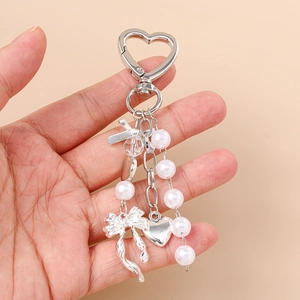 Silver heart carabiner keychain with white pearls, metal bow, and solid heart pendant