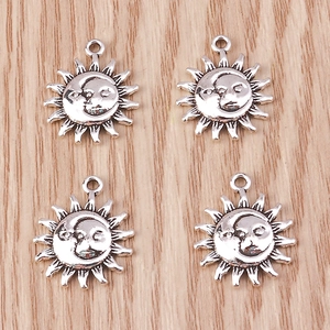Macro detail of antique silver sun and moon face pendants for DIY jewelry making