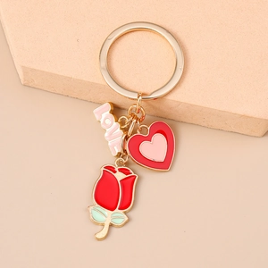 Détail du porte-clés avec anneau doré, breloque LOVE, cœur et pendentif rose rouge