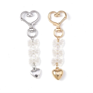 Portachiavi a cuore oro e argento con fiocchi di perle bianche su sfondo bianco