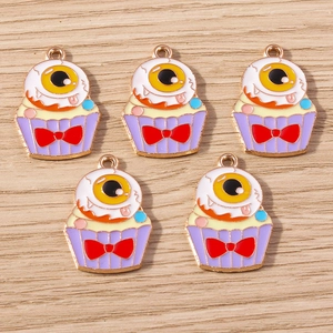 Macro shot of colorful eyeball cupcake charms with golden metal edges for DIY jewelry