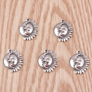 Detailed macro view of 5 vintage silver celestial sun and moon charm pendants